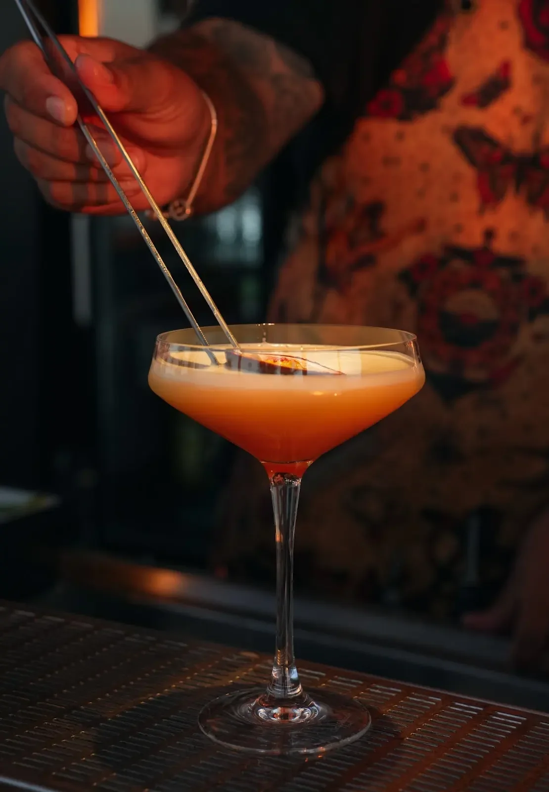 A cocktail being finished at the bar