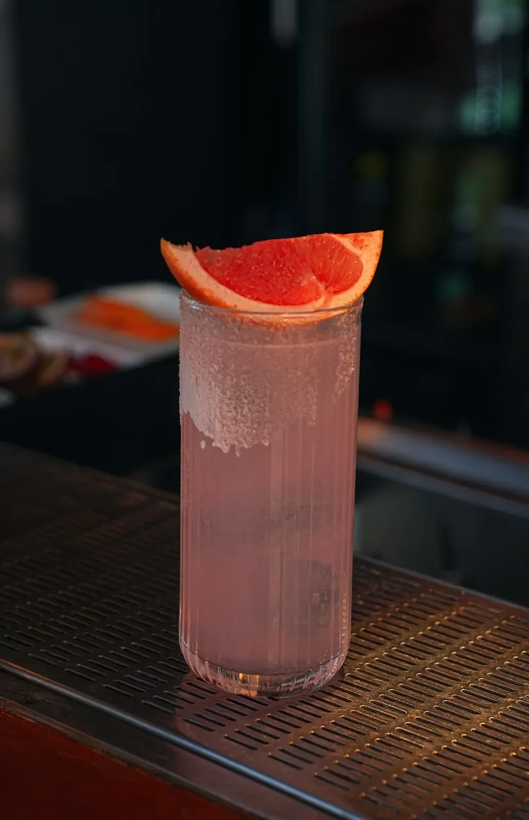 A pink cocktail served by the water